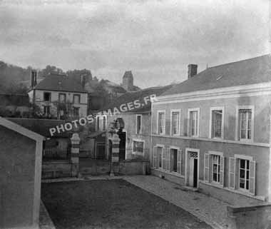 Photo ancienne de la cour d'une maison et du clocher de l'église de Dormans en 1914