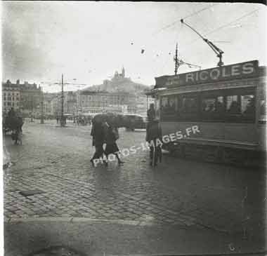 Ancienne photo du port de Marseille avec le tramway et la basiliqueun jour de pluie en 1920