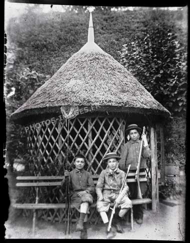 Les trois garçons posent pour la photo devant la paillote, abri de jardin.